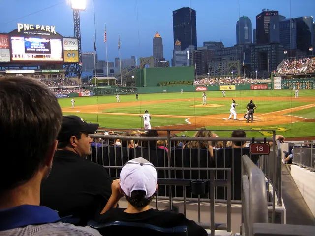 This is a picture of a stadium , where there are group of people , iron grills, group of people...